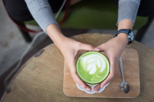 Person holding a cup of matcha green tea. Drinking it for its antioxidant properties